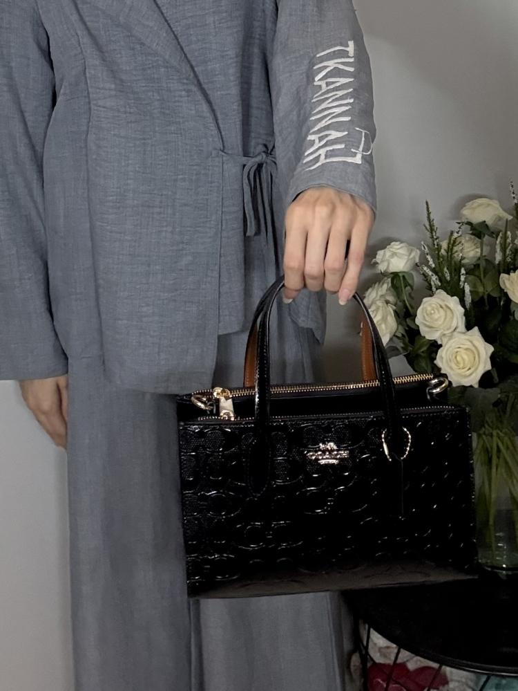 شنطة كوتش توت صغيره نينا سجنشر بلون اسود اامبوزد Nina Small Tote Bag In Signature Leather Black