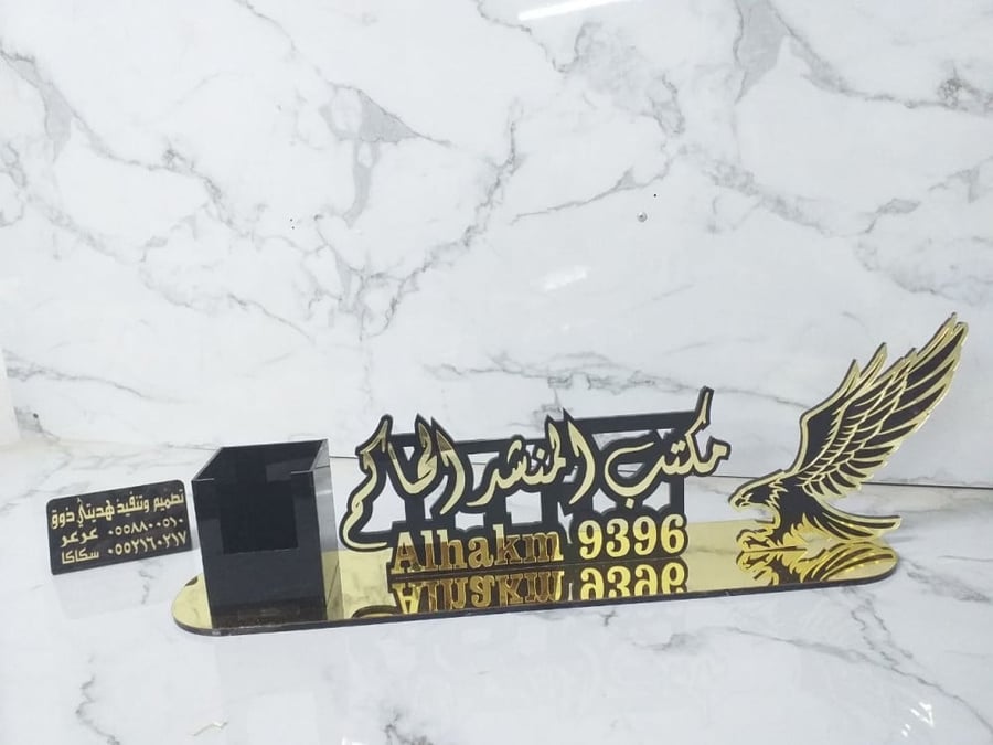 Office nameplate with a falcon and a pen.