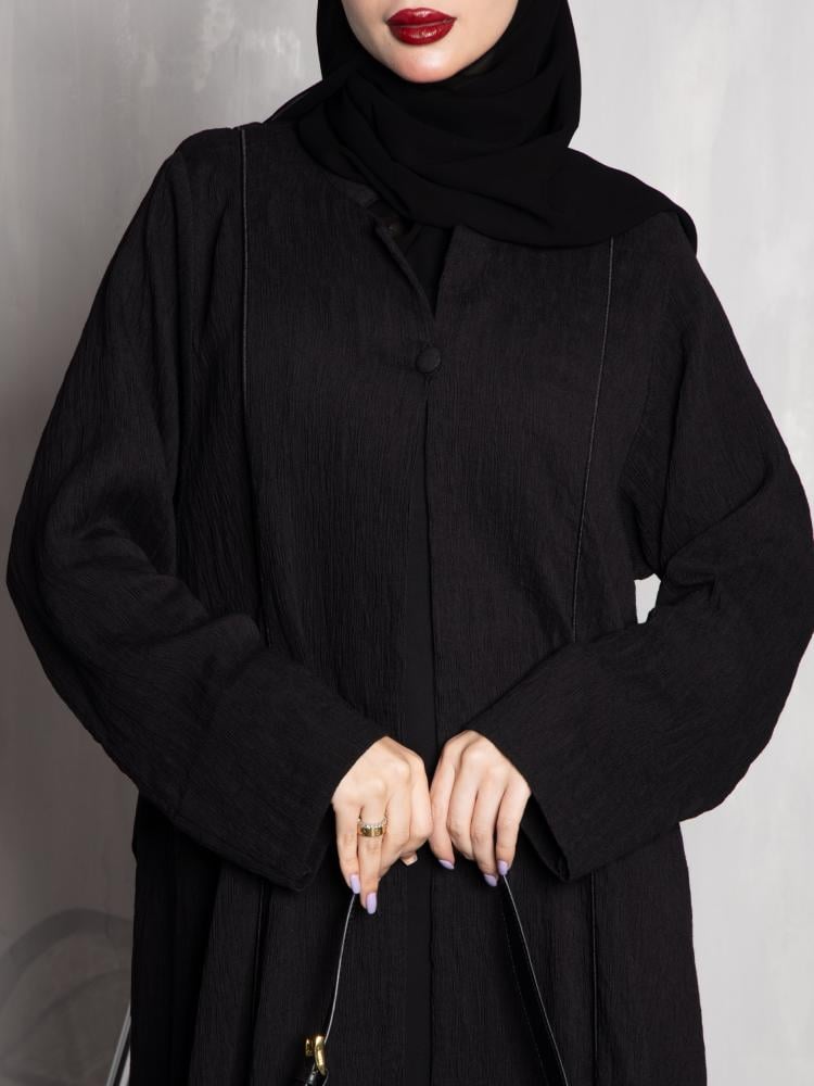 عباية نسائية سوداء سادة بقماش محزز وتصميم كلوش واسع مع أزرار أمامية مخفية | عبايات عملية أنيقة للدوام والخروج اليومي
