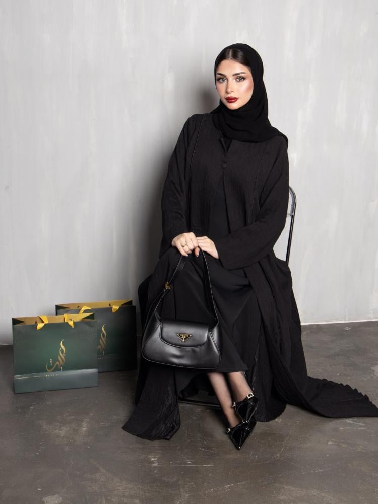 عباية نسائية سوداء سادة بقماش محزز وتصميم كلوش واسع مع أزرار أمامية مخفية | عبايات عملية أنيقة للدوام والخروج اليومي