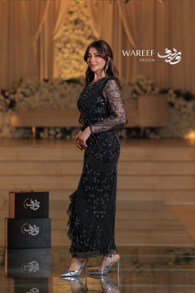 A tight black dress decorated with luxurious embroidery