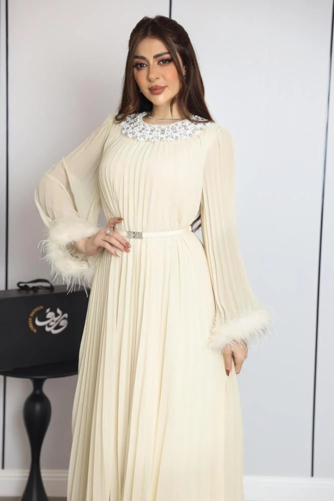 فستان ناعم نسائي بلون كريمي بياقة مرصعة وأكمام شيفون مزينة بالريش
