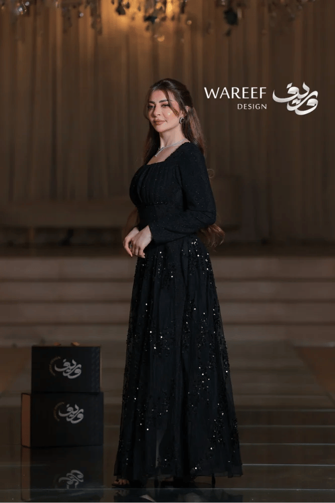 Long black evening dress, luxurious, with long sleeves and a square neckline, wide cut, made of soft fabric with sequin embroidery