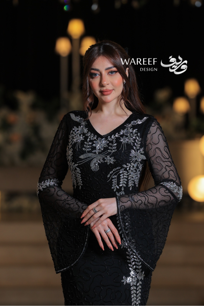 فستان سهرة أسود فاخر مطرّز بالفضي وأكمام دانتيل منسدلة لإطلالة ملكية راقية