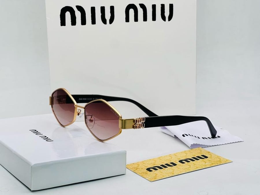 نظارات شمسية ماسية الشكل أنيقة من Miu Miu بإطار ذهبي وعدسات متدرجة باللون البني.