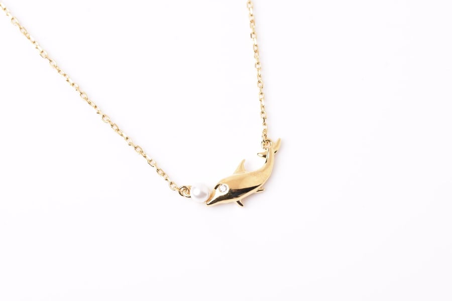 Gold-colored silver necklace in the shape of a whale