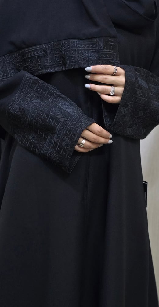 Black abaya, elegant fabric, standing with a blunt belt