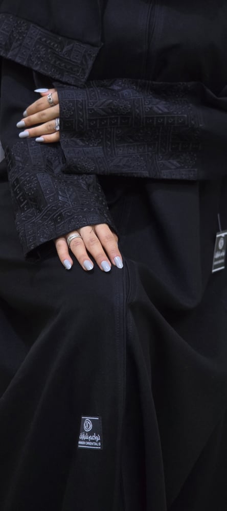 Black abaya, elegant fabric, standing with a blunt belt