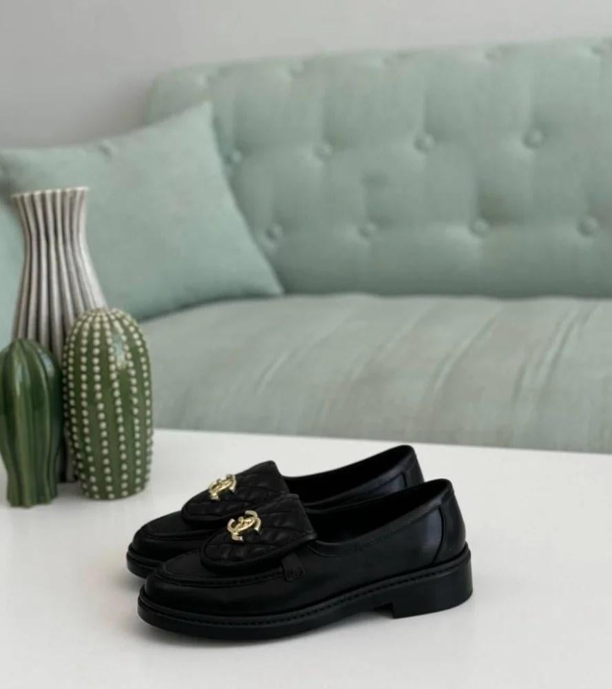 Black leather loafers padded from Chanel, gold circular lock