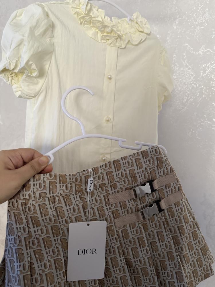 Luxurious two-piece Dior outfit, the blouse decorated with pearl buttons, and the complete set with an elegant finish