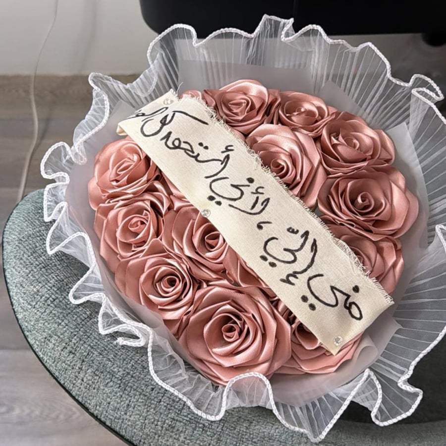 باقه 15 ورده مع تغليف قماش وشريطه مع الكتابه
