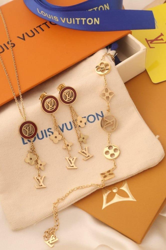 مجموعة مجوهرات من ماركة Louis Vuitton، تشمل عقد وسوار وأقراط تحمل شعار LV الشهير مع تصميمات زهرية مميزة.