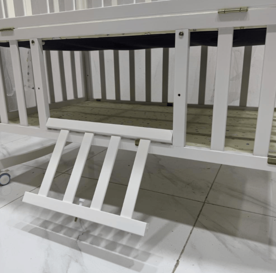 سرير أطفال مع ناموسية أبيض بحواف ملونة وعجلات بتصميم مرح وأنيق