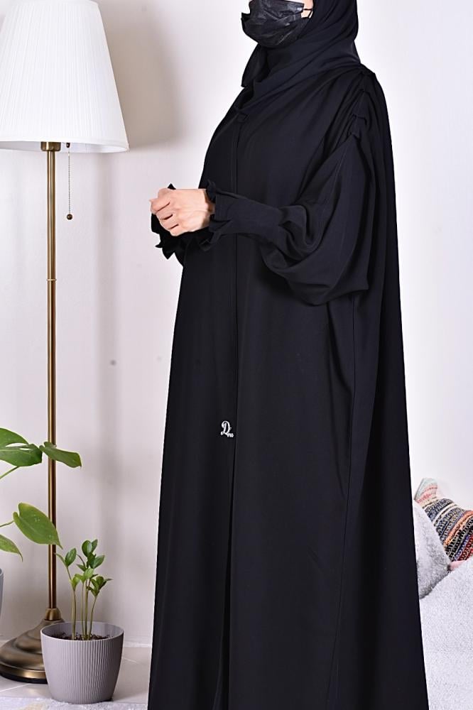 The phrase contains a typo and is not entirely clear. However, based on the context and common usage, it likely means:

"Abaya of elegance - plain"
