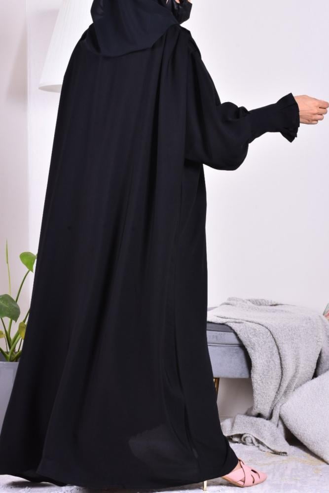 The phrase contains a typo and is not entirely clear. However, based on the context and common usage, it likely means:

"Abaya of elegance - plain"