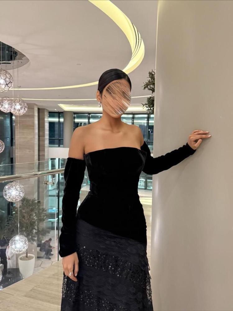 فستان سهرة أسود دون أكتاف بأكمام طويلة وتنورة لامعة
