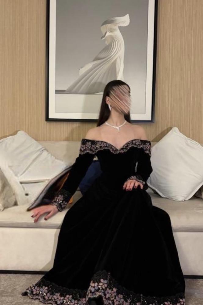 فستان سهرة أسود بأكتاف مكشوفة وتنورة مطرزة الحافة