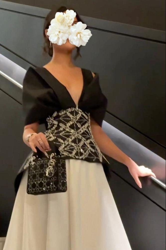 فستان سهرة أسود وعاجي بخصر هندسي مرصع