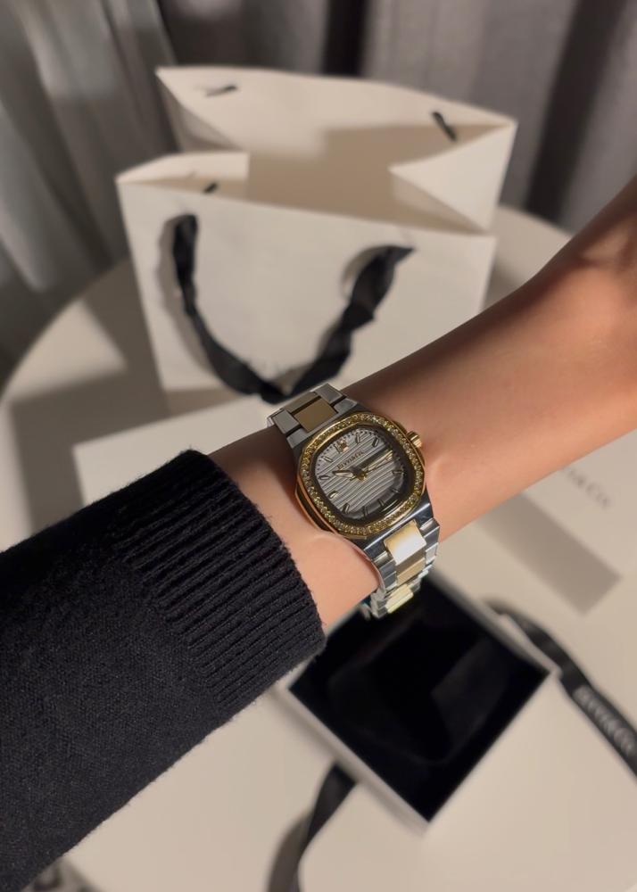A gift containing a bouquet of 25 roses with a watch