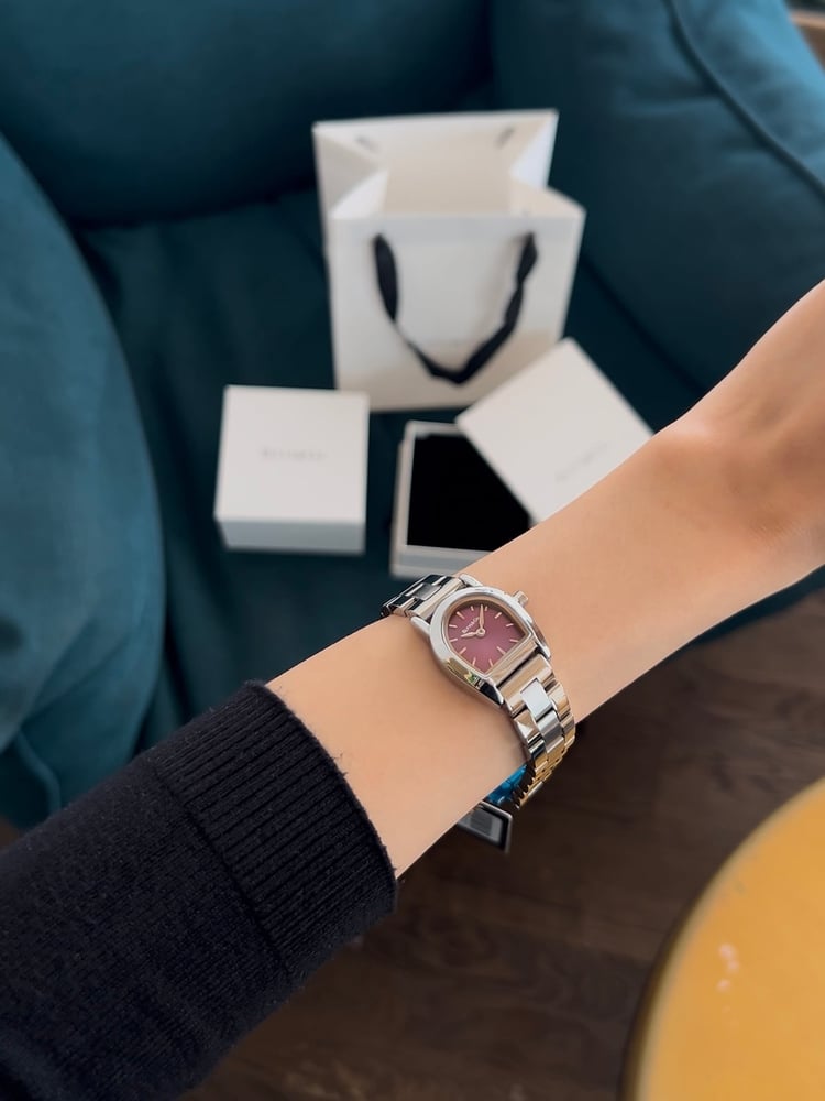 A gift containing a bouquet of 25 roses with a watch