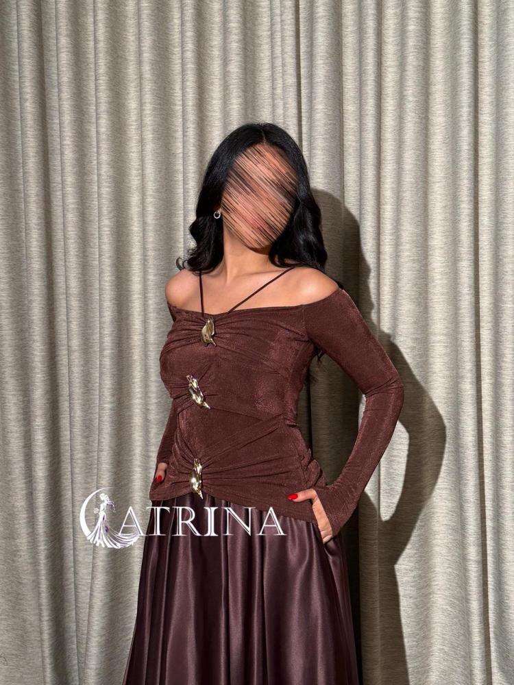 A brown evening dress with an off-shoulder design and elegant metallic details