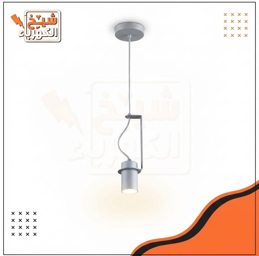 إضاءة معلقة بتصميم عصري وصناعي أنيق باللون الفضي (نيكل أو رمادي فاتح). تتكون من قاعدة سقفية دائرية، وعمود تعليق رفيع، وإطار معدني جانبي يحمل مصباحاً أسطوانياً موجهاً لأسفل يمنح إضاءة مركزة ودافئة