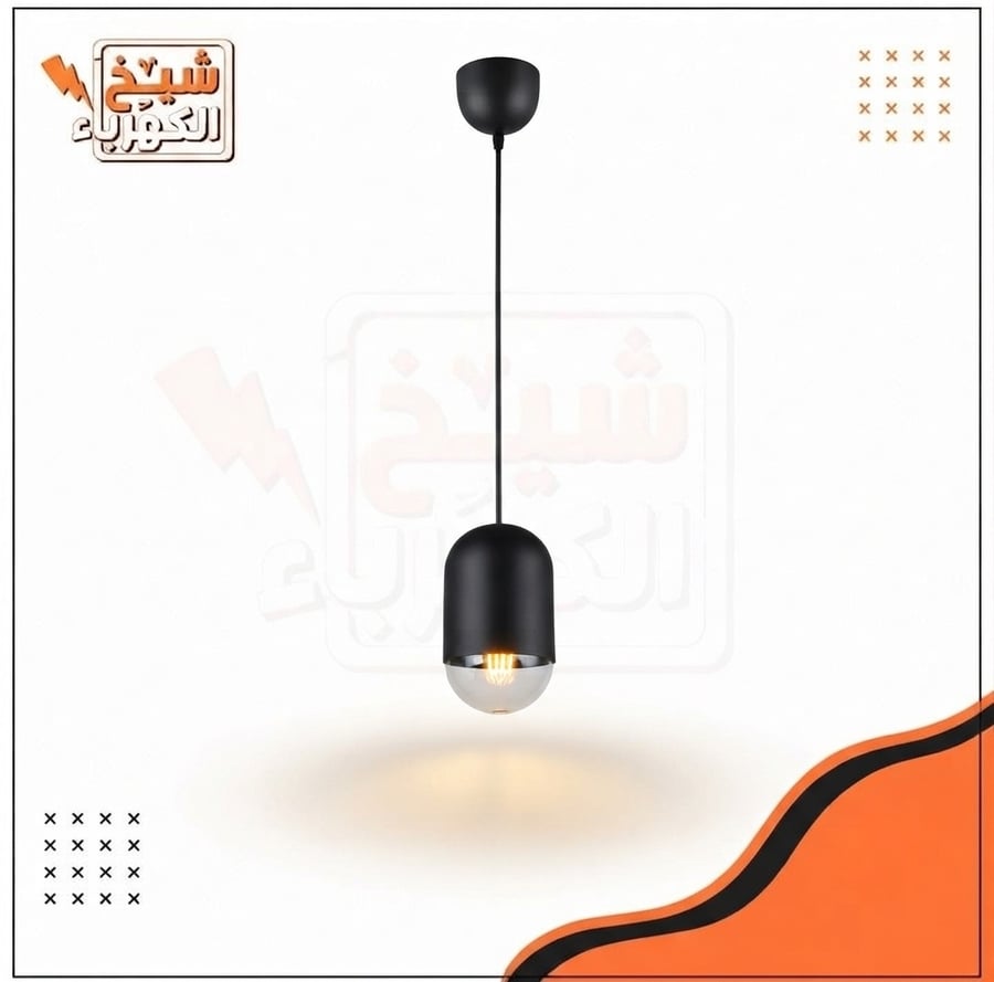 وحدة إضاءة معلقة (سلندر) سقفية بتصميم أسطواني قصير وعصري بلون أسود مطفي مع جزء سفلي زجاجي مدخن شفاف يكشف عن لمبة ليد ديكورية دافئة، مُعلقة بسلك متين تتصل بقاعدة سقفية نصف دائرية، لتمنح إضاءة ناعمة وموزعة تعكس هوية معمارية راقية وتلبي احتياجات الإضاءة الحد