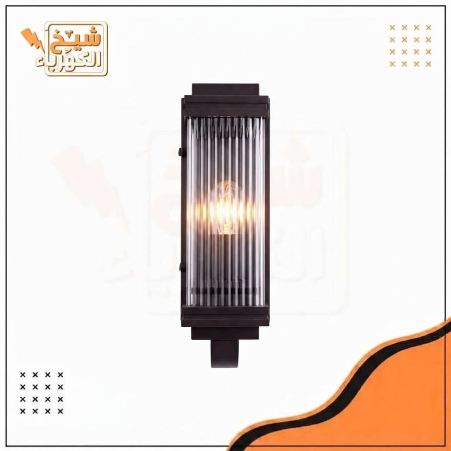 أبليك جداري خارجي بتصميم هندسي مستطيل يضم زجاجاً داخلياً مضلعاً يعكس الإضاءة بشكل أنيق، مع هيكل معدني متين ومقاوم للعوامل الجوية بلون أسود مطفأ، ليضفي إضاءة مميزة ومظهرًا فاخرًا على الواجهات والمداخل الخارجية