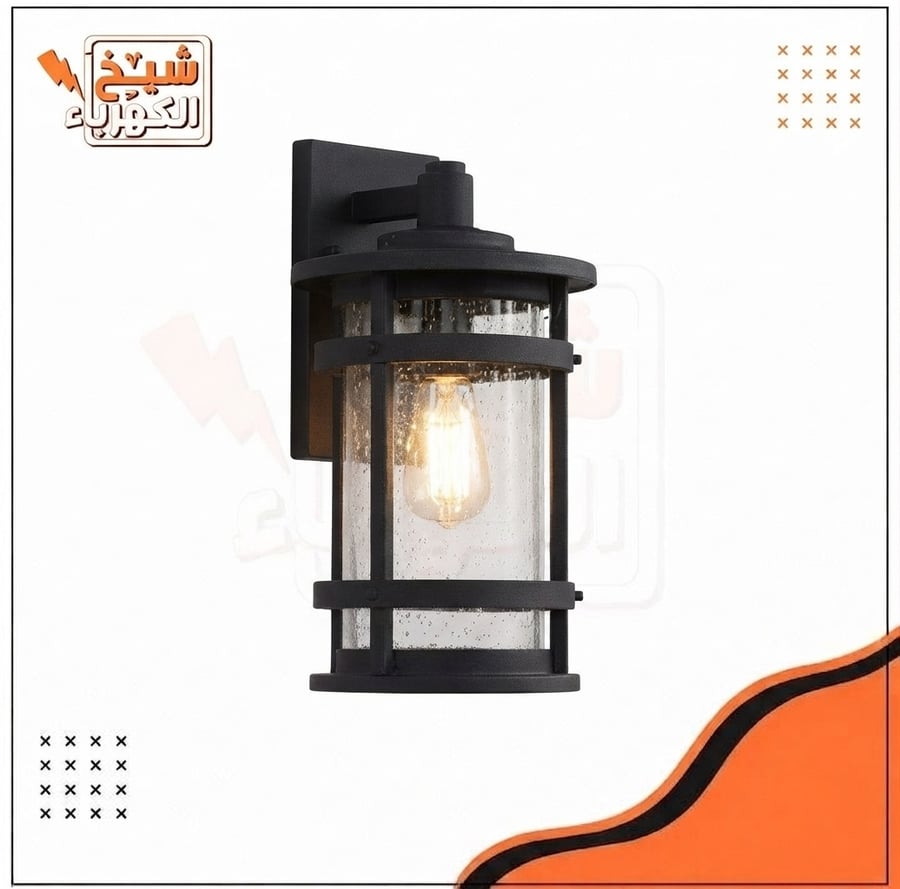 أبليك جداري خارجي أسود بتصميم فانوس أسطواني معلق بزجاج مموج وأشرطة حماية أفقية قوية يحيط بلمبة دافئة، يمنح إضاءة محيطية دافئة ومميزة للواجهات والمداخل الخارجية