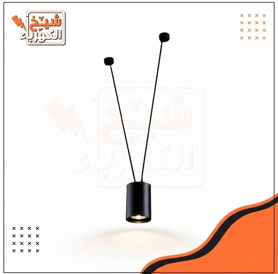 وحدة إضاءة معلقة بتصميم معدني أسود بكتلة أسطوانية (سلندر) مدعومة بأسلاك تثبيت مزدوجة، لتوفير إضاءة موجهة ومركزة تضفي طابعاً معمارياً معاصراً ودقيقاً على المساحات الداخلية