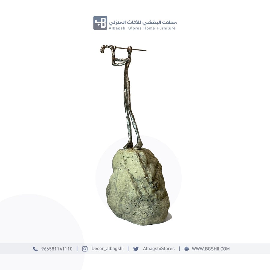 تحفة ديكور مجسم شخص فوق صخرة