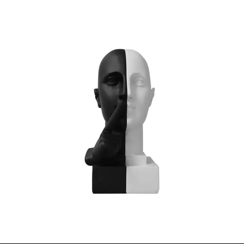 تمثال ديكور لوجه نصفه أسود ونصفه أبيض يضع إصبعه على شفتيه