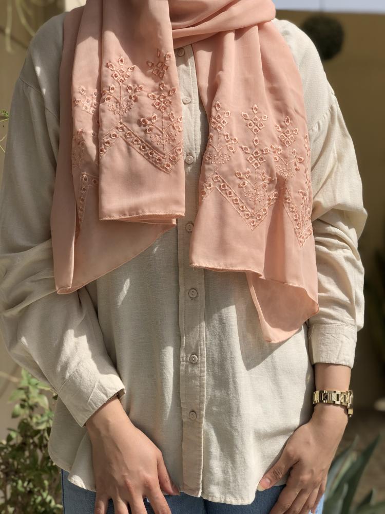 A beige-colored headscarf with embroidery on both ends