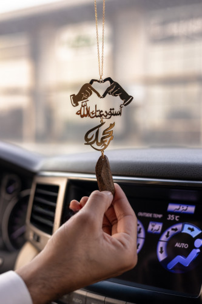 A pendant of a broken oud in the shape of a heart with two hands, trendy