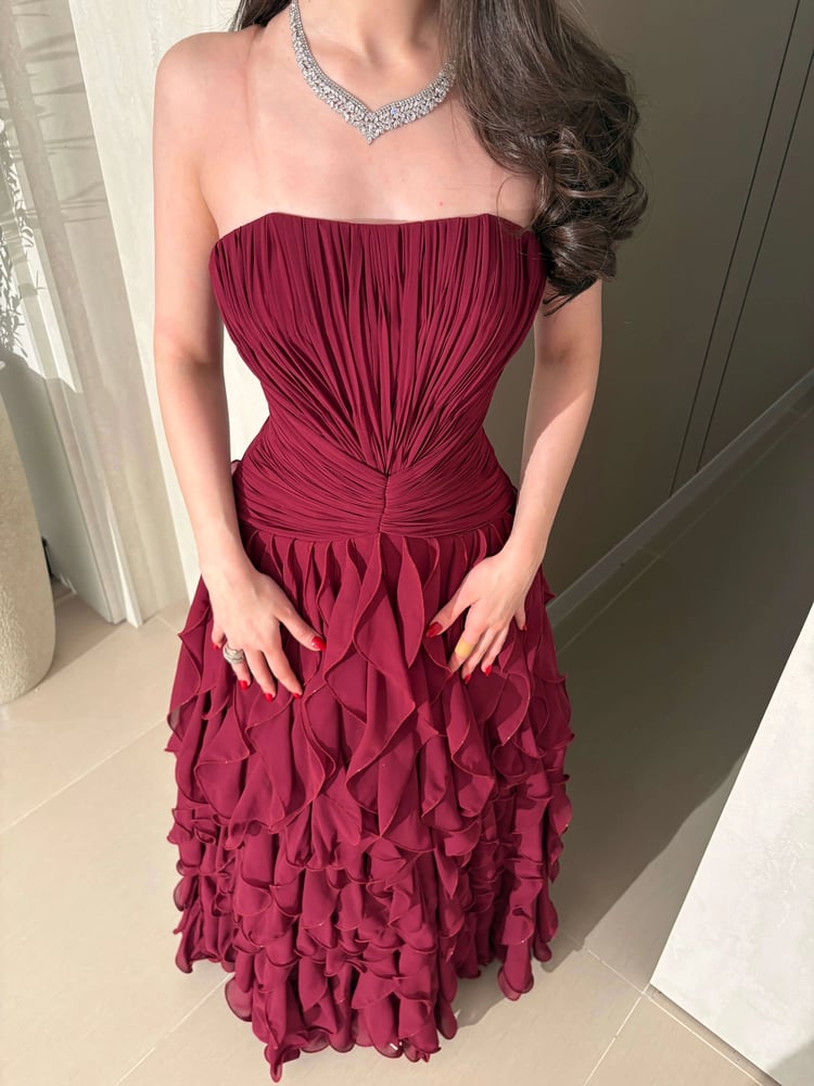 فستان سهرة عنابي فاخر بطبقات كشكش انسيابية وتصميم كورسيه