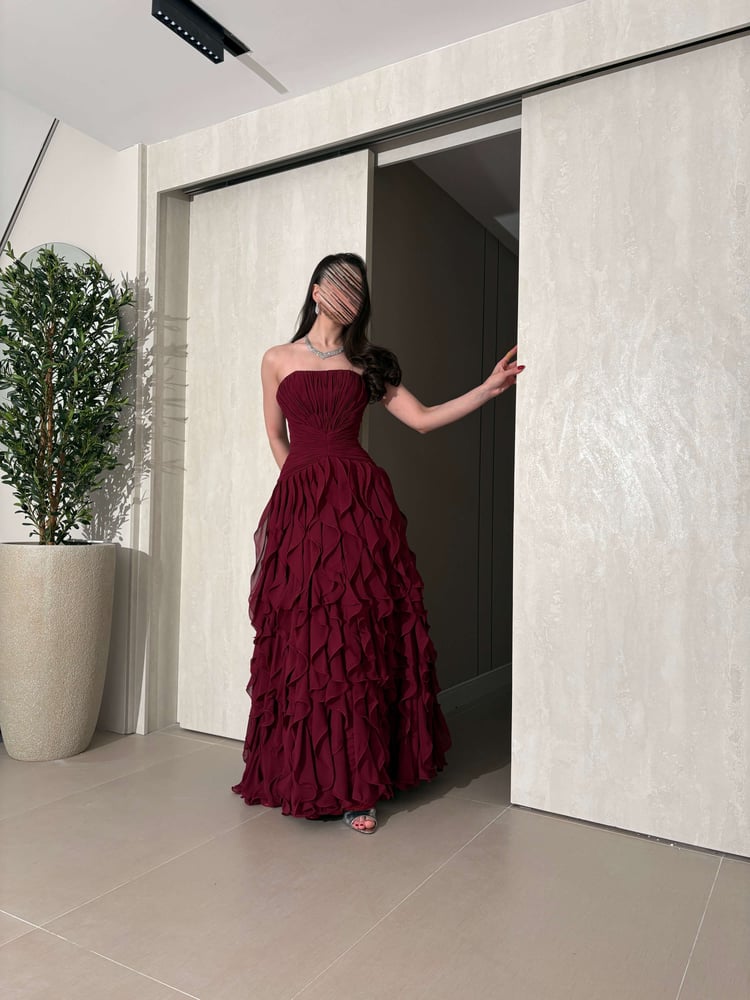 فستان سهرة عنابي فاخر بطبقات كشكش انسيابية وتصميم كورسيه