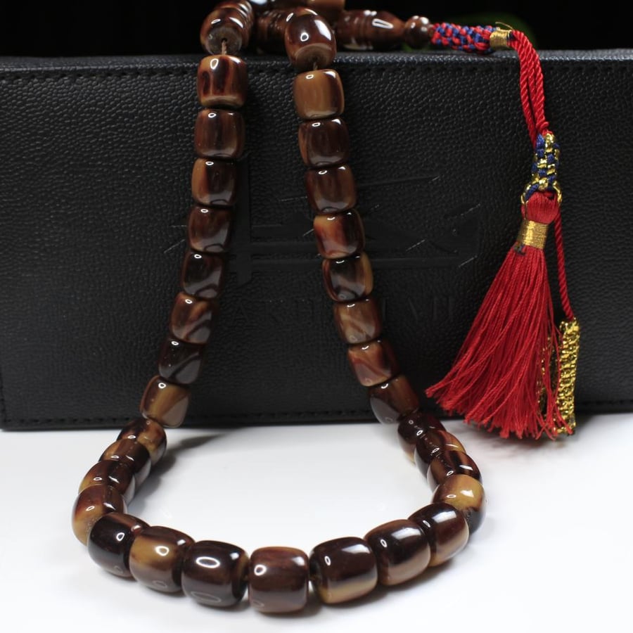 A brown musk prayer bead with a gradient cinnamon color