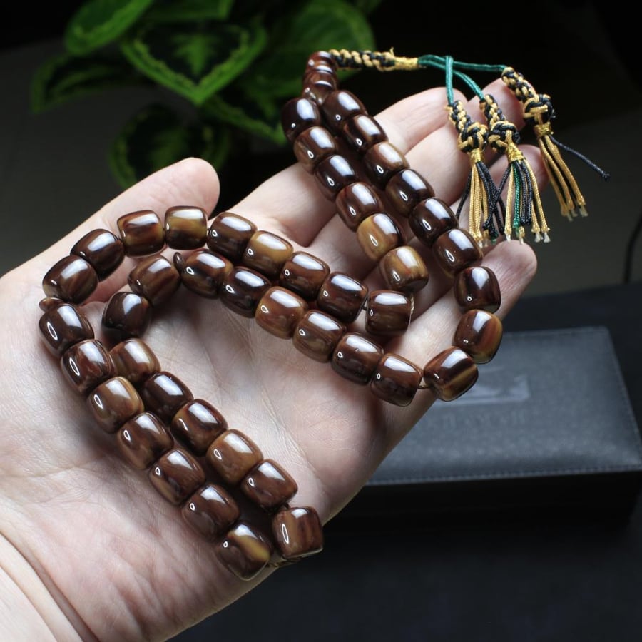 A brown musk prayer bead with a gradient cinnamon color