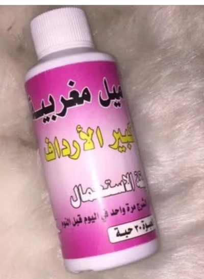 عبوة تحاميل مغربية لتكبير الأرداف باللونين الوردي والأبيض موضوعة على خ