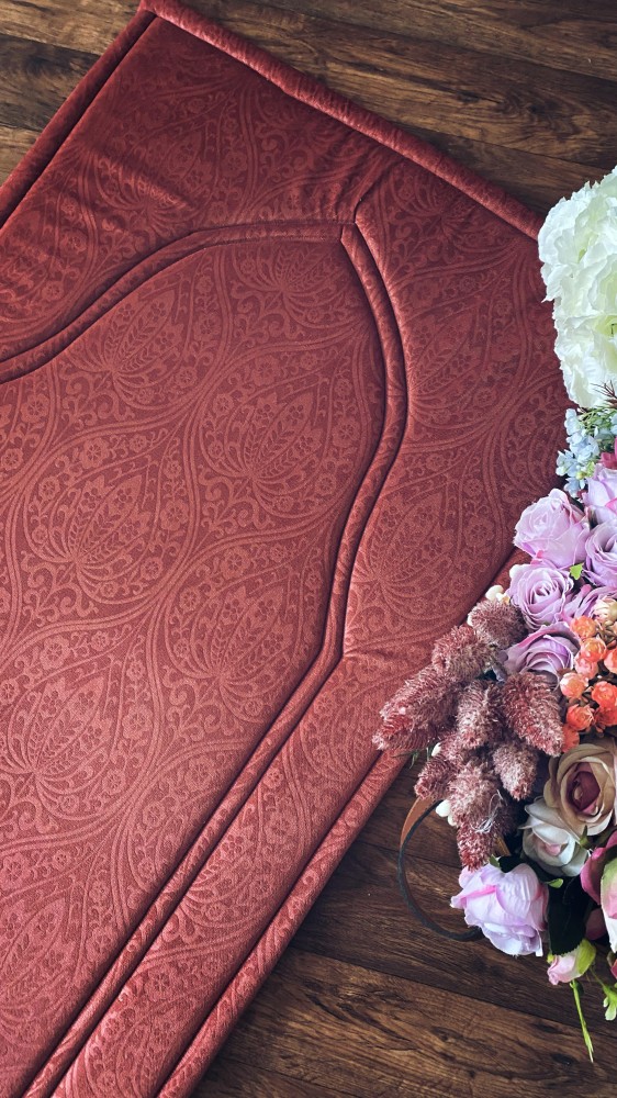 An orange-reddish prayer rug