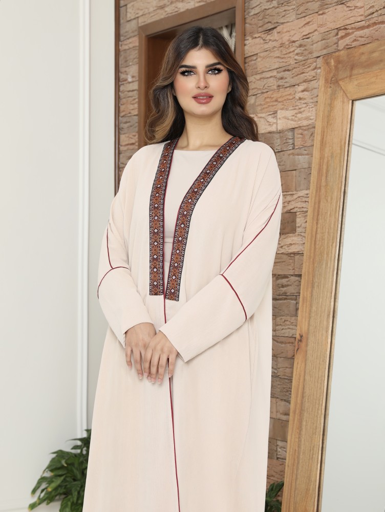Distinctive abaya, lightweight crepe fabric, with embroidered embellishment from the front and on the sleeves, in a coral red color to highlight the beauty of the abaya model.
