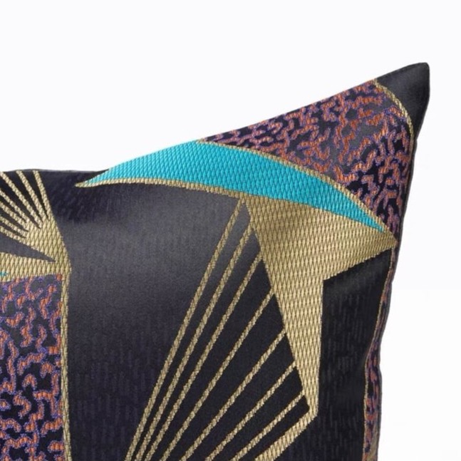 A cushion with a mix of colors black, gold, blue, purple
