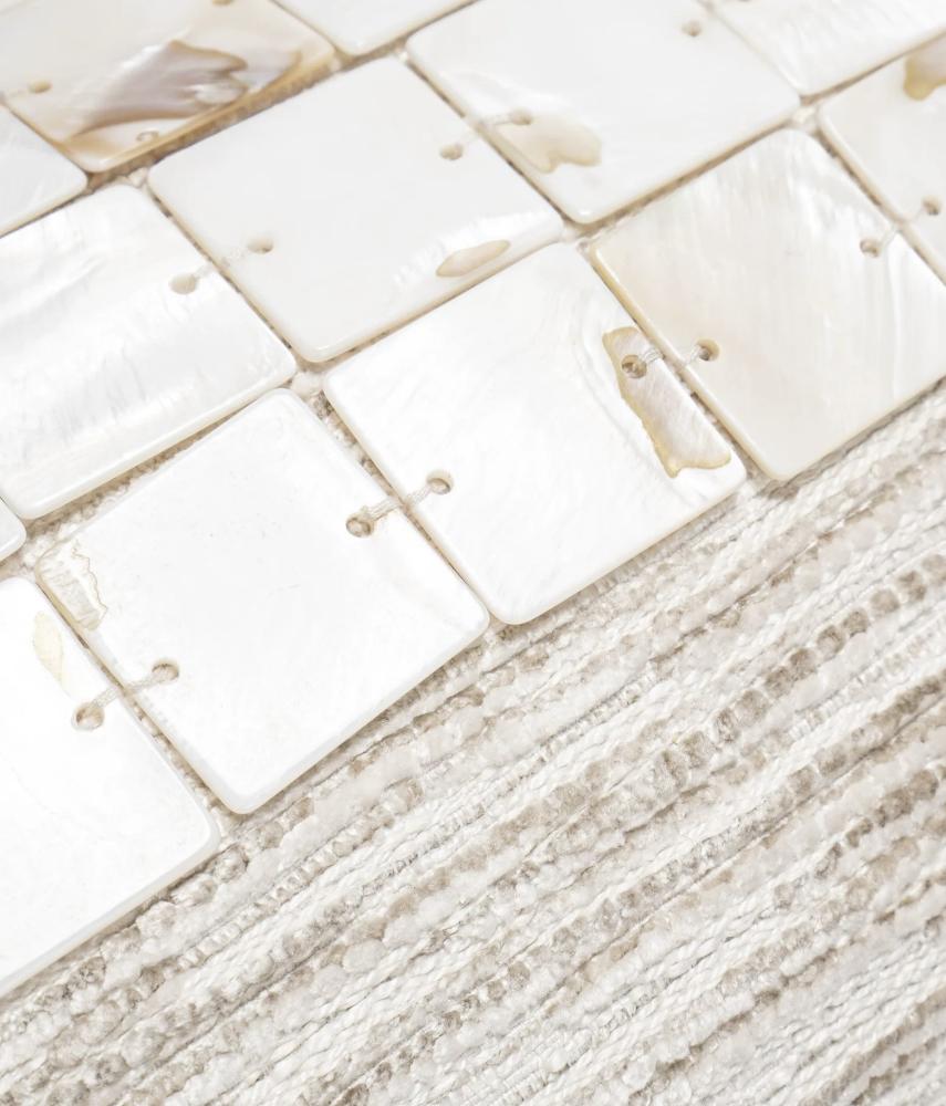 A fabric pillow decorated with shell pieces