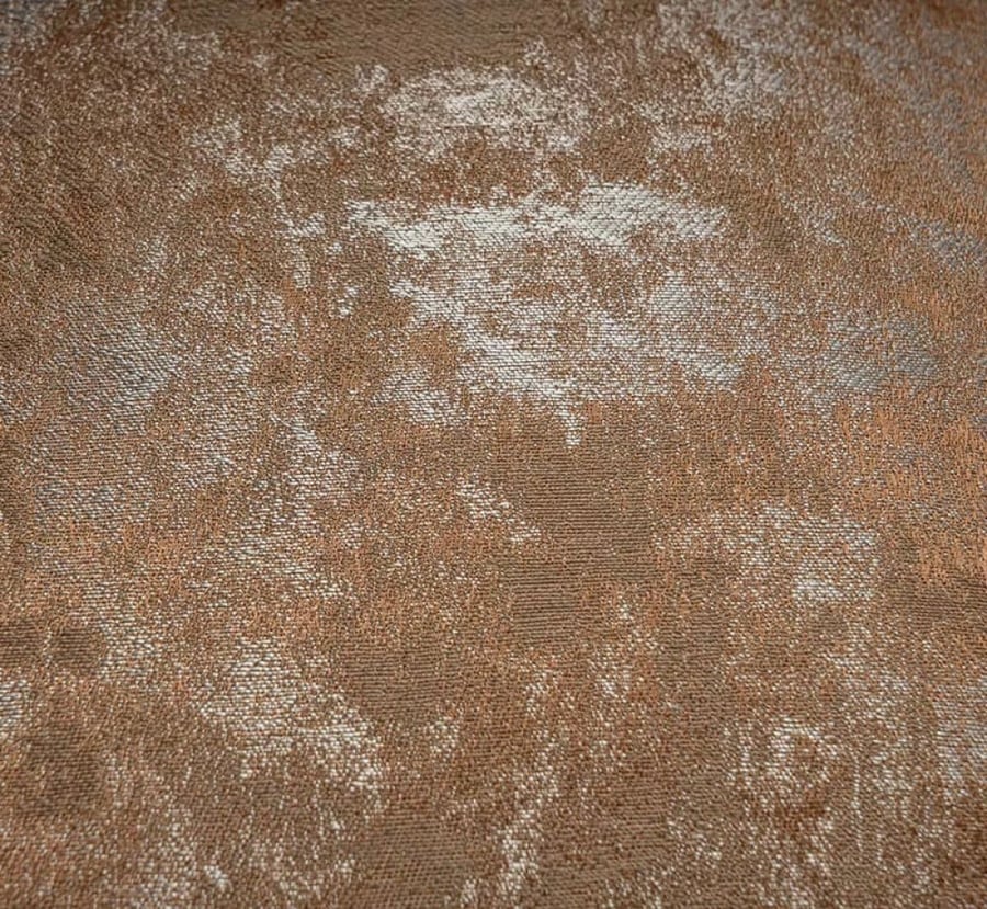 A cushion cover in a mix of brown, orange, and silver shimmer.