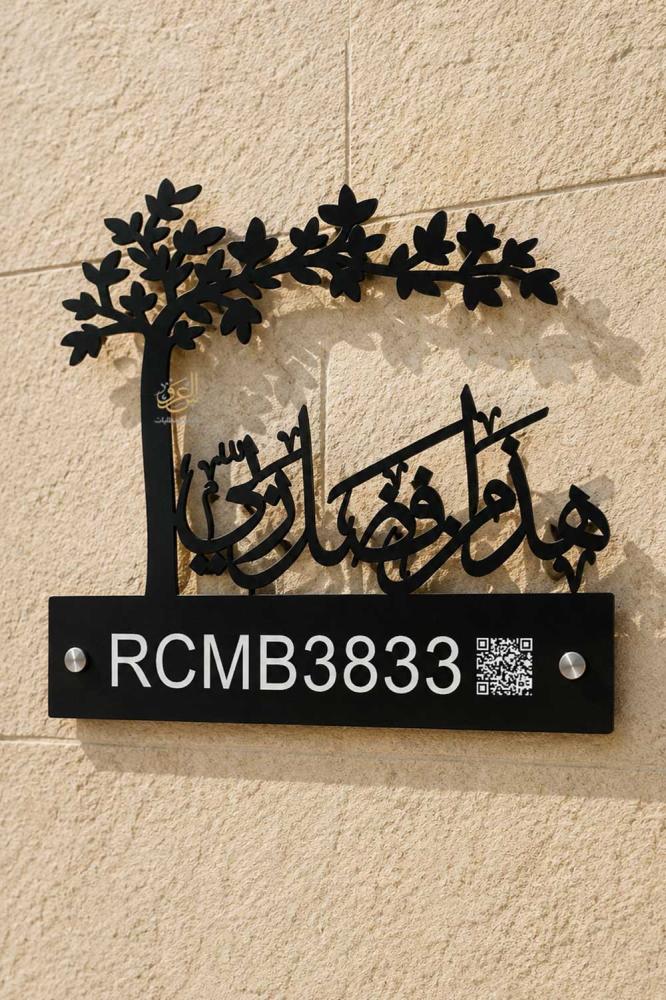 لوحة عنوان وطني سوداء بشكل شجرة مثبتة على جدار فيلا حجرية مع حفر أبيض