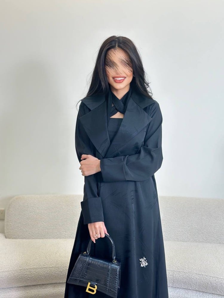 A Jakar fabric abaya with a loose fit, and in the back a black Julia fabric, with a black headscarf.