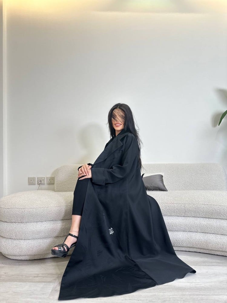 A Jakar fabric abaya with a loose fit, and in the back a black Julia fabric, with a black headscarf.