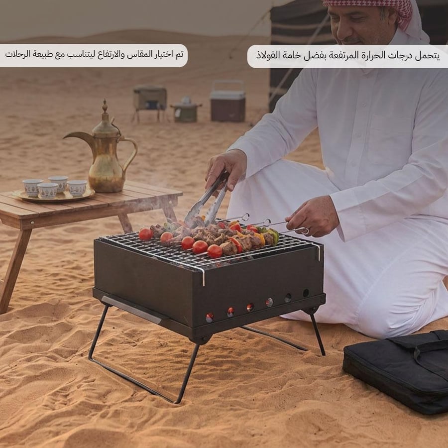 شخص يستخدم شواية فحم متنقلة من الحديد على الرمال في البر مغطاة بشبكة