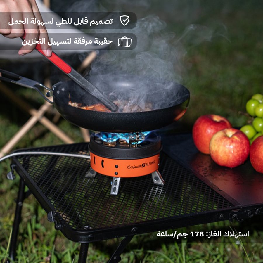 موقد غاز متنقل برتقالي على طاولة تخييم يستخدم للطهي السريع يظهر