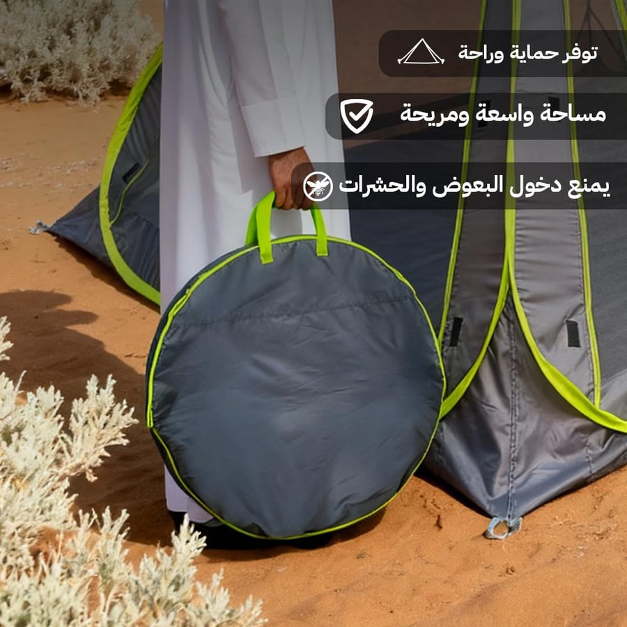 حقيبة دائرية رمادية لمظلة ناموسية للبر تظهر قرب خيمة على الرمال مزودة